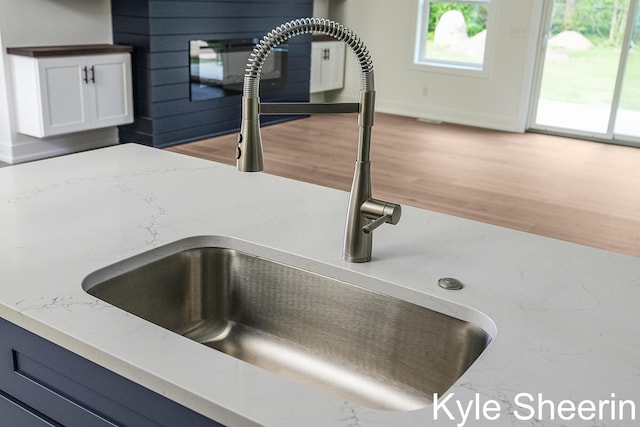 8060 Hunters Xing, Kalamazoo, MI 49009 - kitchen view of a sink, light stone countertops, light wood-type flooring, and white cabinets