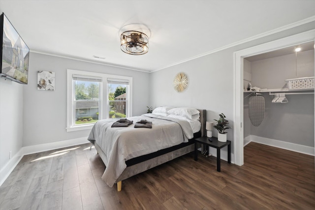 289 Newport St, Detroit, MI 48215 - bedroom with crown molding, wood finished floors, a walk in closet, and baseboards