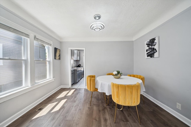 289 Newport St, Detroit, MI 48215 - dining area with wood finished floors, baseboards, and a textured ceiling