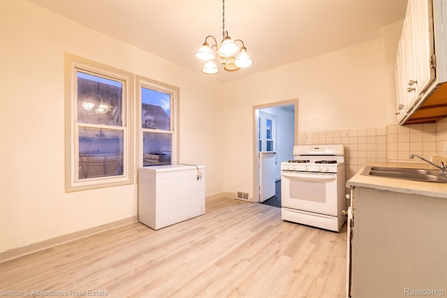 11620 Nagel St, Hamtramck, MI 48212 - kitchen with white range with gas cooktop, fridge, a sink, light countertops, and light wood-type flooring