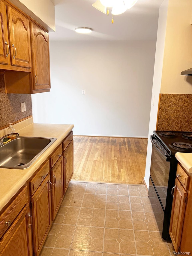 25731 Salem Ct Unit 63, Roseville, MI 48066 - kitchen featuring black range with electric stovetop, light countertops, brown cabinetry, and tasteful backsplash