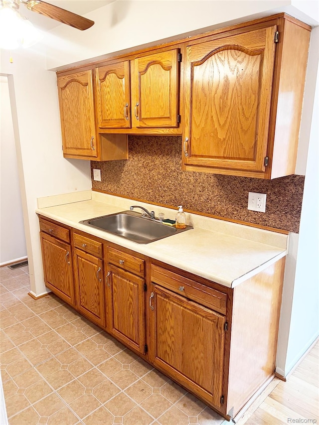 25731 Salem Ct Unit 63, Roseville, MI 48066 - kitchen featuring ceiling fan, light countertops, brown cabinets, and tasteful backsplash
