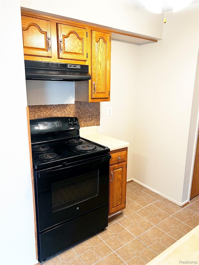 25731 Salem Ct Unit 63, Roseville, MI 48066 - kitchen with black range with electric stovetop, under cabinet range hood, light countertops, and brown cabinetry