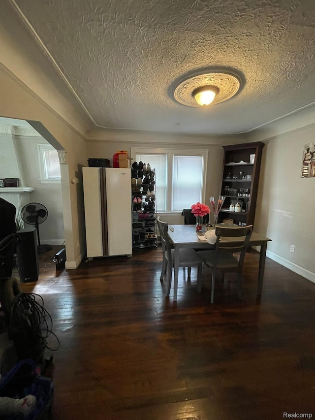 15395 Littlefield St, Detroit, MI 48227 - dining space with arched walkways, a textured ceiling, healthy amount of natural light, dark wood-style floors, and baseboards