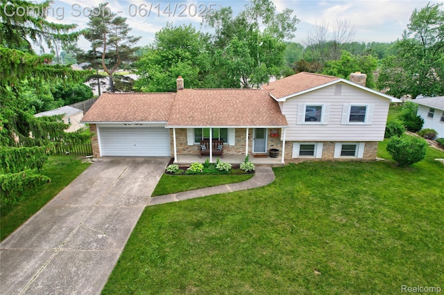5388 N Georgetown Rd, Grand Blanc, MI 48439 - tri-level home with a chimney, brick siding, an attached garage, covered porch, and driveway