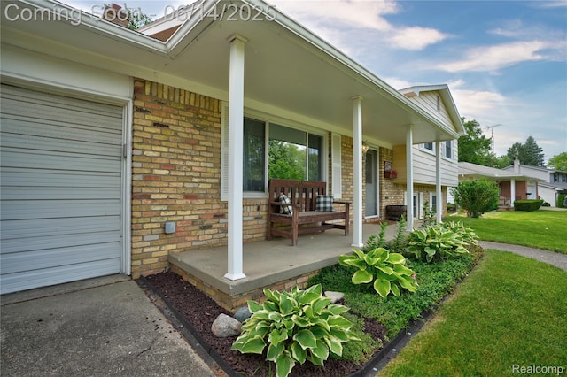 5388 N Georgetown Rd, Grand Blanc, MI 48439 - view of exterior entry with brick siding, covered porch, and a lawn