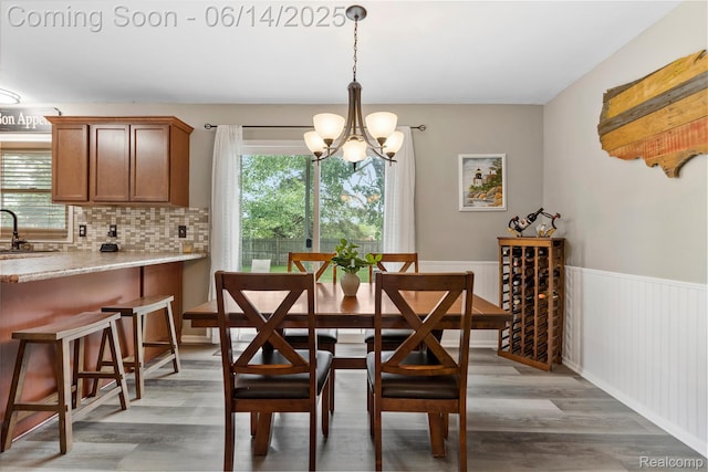 5388 N Georgetown Rd, Grand Blanc, MI 48439 - dining space with a chandelier, light wood-style flooring, and a wainscoted wall