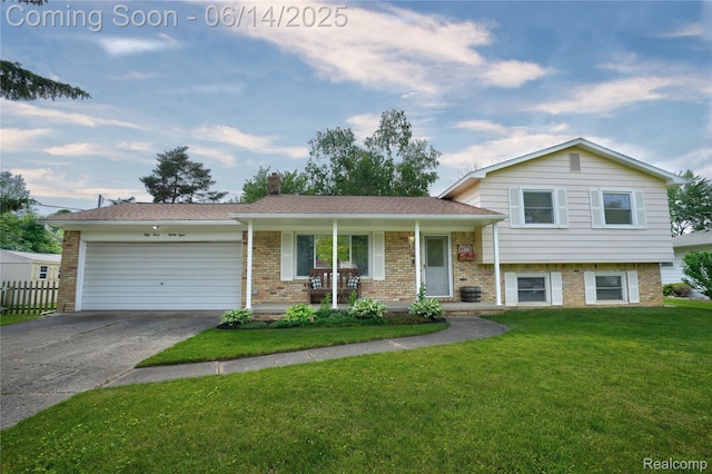 5388 N Georgetown Rd, Grand Blanc, MI 48439 - tri-level home with an attached garage, concrete driveway, brick siding, a chimney, and a porch