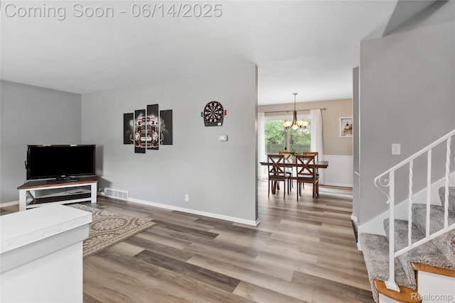 5388 N Georgetown Rd, Grand Blanc, MI 48439 - living area featuring stairway, wood finished floors, and a chandelier