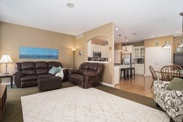 1300 St Andrews Dr, Holland, MI 49423 - living area with arched walkways, recessed lighting, and wood finished floors