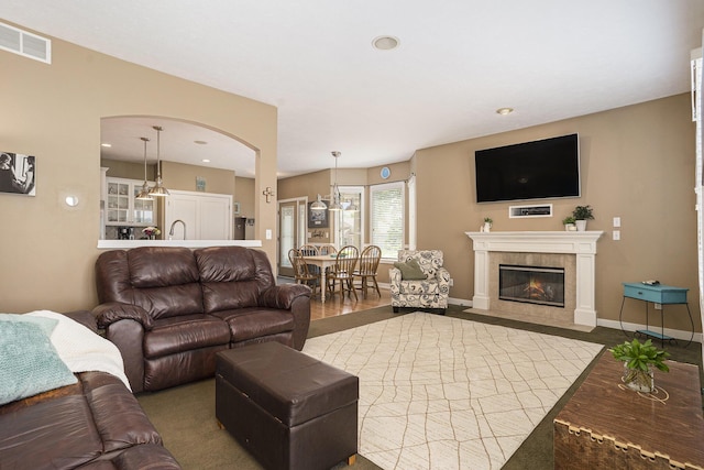 1300 St Andrews Dr, Holland, MI 49423 - living area featuring wood finished floors, a fireplace, recessed lighting, baseboards, and arched walkways