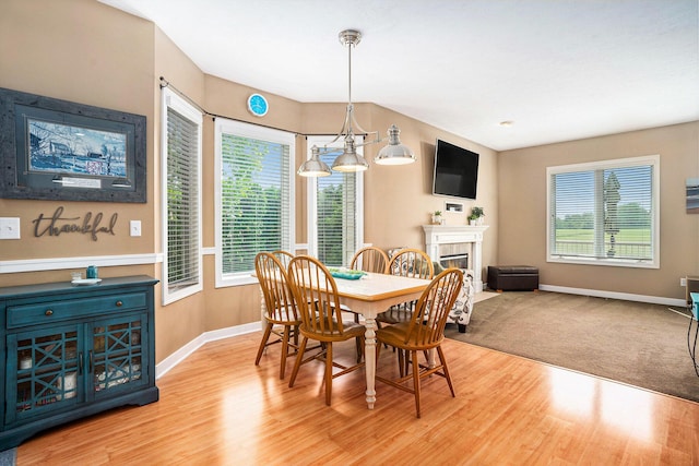 1300 St Andrews Dr, Holland, MI 49423 - dining area with baseboards, light wood-style floors, and a tiled fireplace