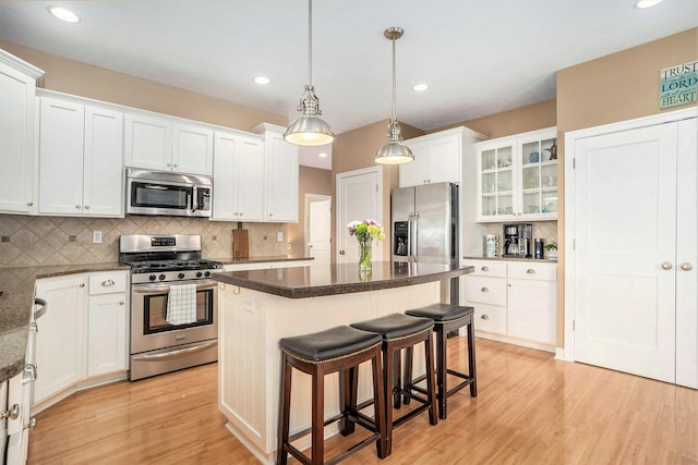 1300 St Andrews Dr, Holland, MI 49423 - kitchen featuring stainless steel appliances, a center island, light wood-style floors, white cabinets, and tasteful backsplash