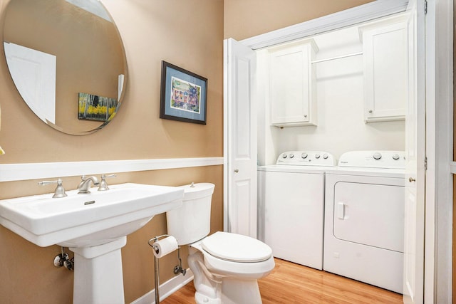 1300 St Andrews Dr, Holland, MI 49423 - bathroom featuring washer and dryer, wood finished floors, toilet, and a sink