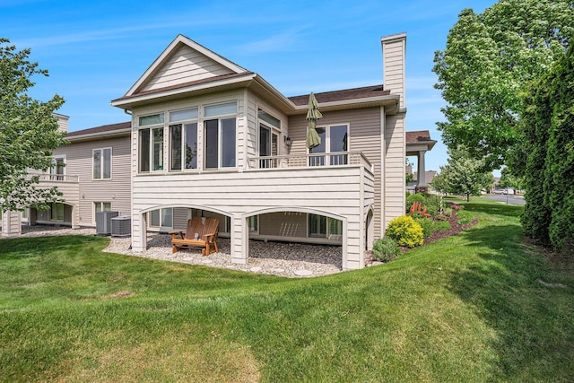 1300 St Andrews Dr, Holland, MI 49423 - rear view of house featuring a chimney, a lawn, and central AC unit