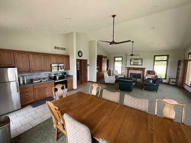 1300 St Andrews Dr, Holland, MI 49423 - dining space featuring ceiling fan, a tiled fireplace, high vaulted ceiling, light tile patterned floors, and recessed lighting
