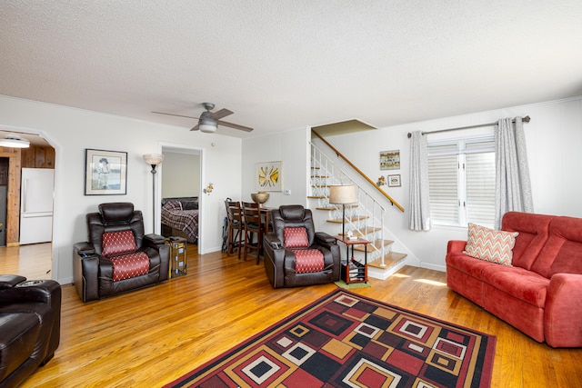 114 W Grove Ave, Michigan Center, MI 49254 - living area with wood finished floors, stairs, a ceiling fan, a textured ceiling, and arched walkways