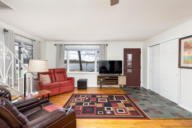 114 W Grove Ave, Michigan Center, MI 49254 - living area with baseboards, a textured ceiling, ornamental molding, wood finished floors, and stairway