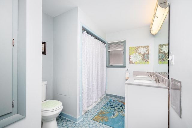 114 W Grove Ave, Michigan Center, MI 49254 - bathroom featuring toilet, double vanity, baseboards, and tile patterned floors