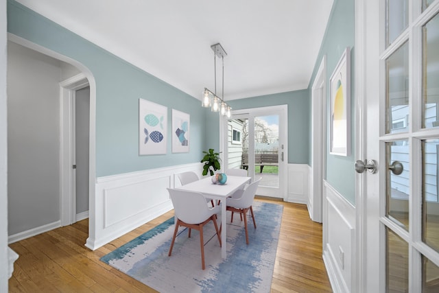 4422 Groveland Ave, Royal Oak, MI 48073 - dining space with light wood finished floors, a wainscoted wall, a decorative wall, arched walkways, and a chandelier