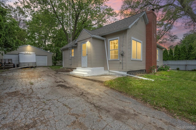 1496 E Parkwood Ave, Burton, MI 48529 - view of front of home featuring a detached garage, an outdoor structure, and a chimney