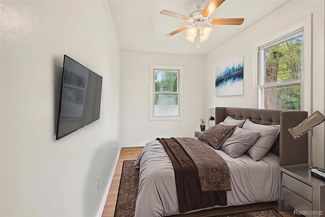 1496 E Parkwood Ave, Burton, MI 48529 - bedroom featuring multiple windows, light wood-type flooring, and ceiling fan