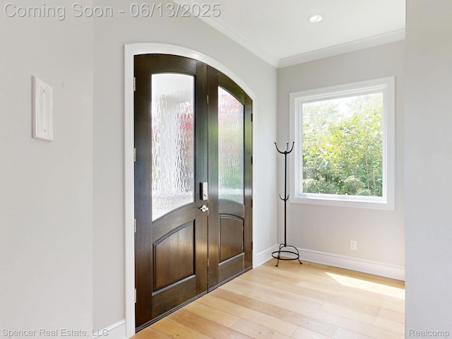 571 Dunleavy Dr, Highland, MI 48356 - entrance foyer with wood finished floors, french doors, baseboards, ornamental molding, and arched walkways