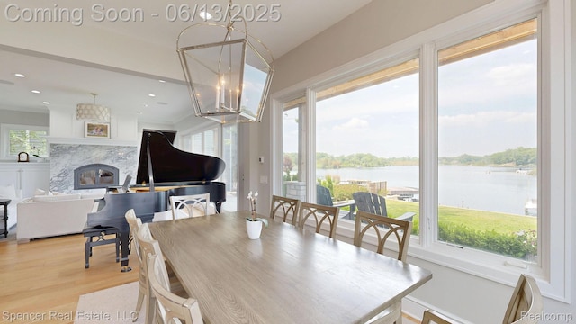 571 Dunleavy Dr, Highland, MI 48356 - dining space featuring a chandelier, a water view, light wood-style floors, plenty of natural light, and recessed lighting