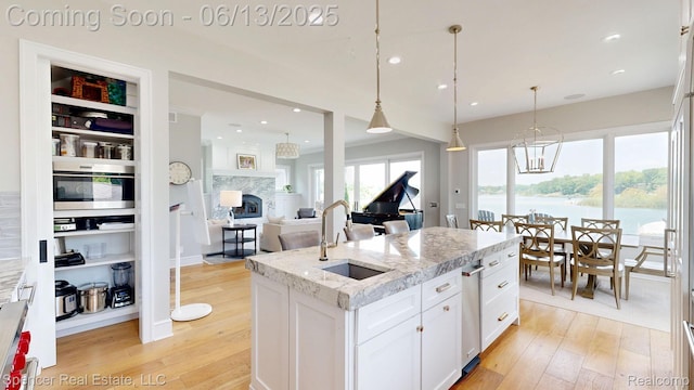 571 Dunleavy Dr, Highland, MI 48356 - kitchen featuring a sink, light wood-style floors, white cabinetry, an island with sink, and recessed lighting