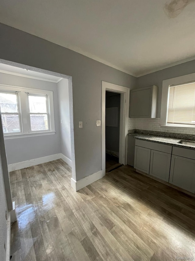 4368 Buckingham Ave, Detroit, MI 48224 - kitchen with light wood-type flooring, baseboards, backsplash, gray cabinets, and ornamental molding