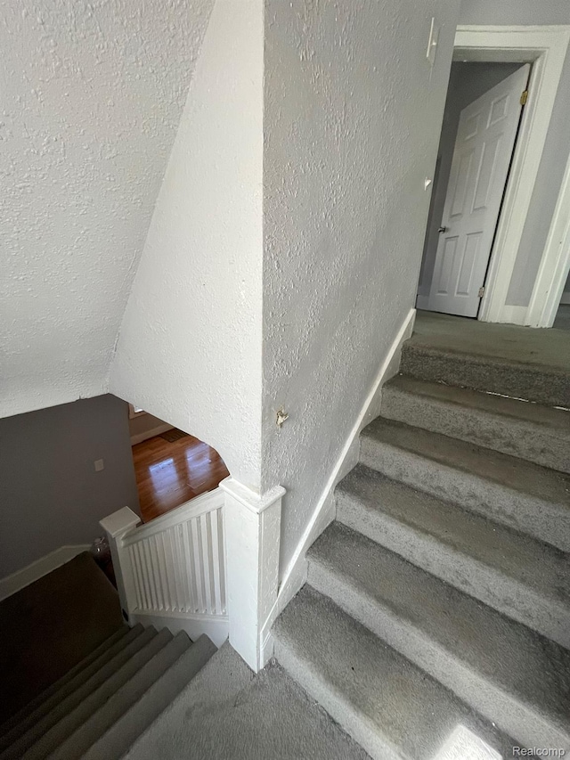 4368 Buckingham Ave, Detroit, MI 48224 - staircase featuring a textured wall, baseboards, a textured ceiling, and lofted ceiling