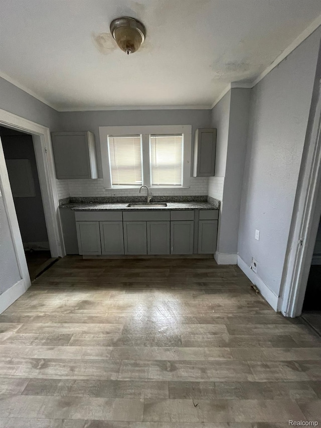 4368 Buckingham Ave, Detroit, MI 48224 - kitchen featuring gray cabinetry, a sink, ornamental molding, baseboards, and backsplash