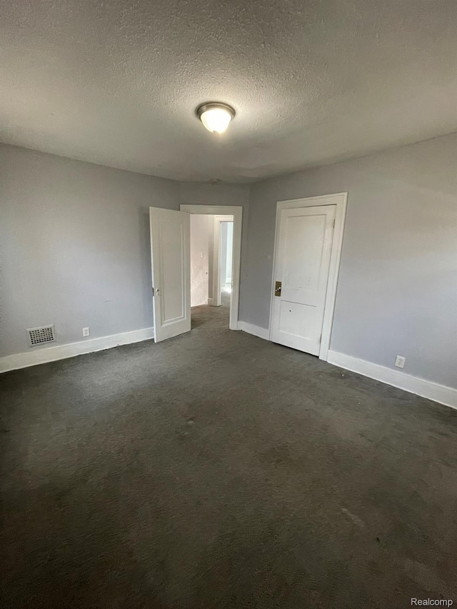 4368 Buckingham Ave, Detroit, MI 48224 - empty room with baseboards, a textured ceiling, and dark carpet