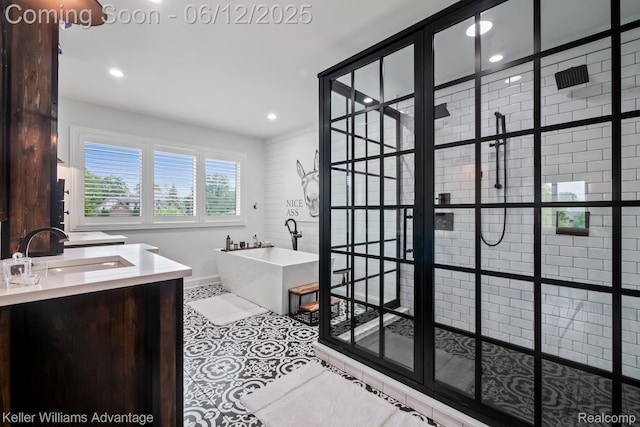 10993 Stoney Point Dr, South Lyon, MI 48178 - full bath featuring a freestanding tub, tiled shower, vanity, recessed lighting, and baseboards