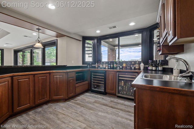 10993 Stoney Point Dr, South Lyon, MI 48178 - kitchen featuring wine cooler, dark countertops, a sink, light wood-style flooring, and recessed lighting