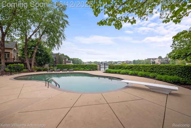 10993 Stoney Point Dr, South Lyon, MI 48178 - view of swimming pool featuring a diving board and a patio