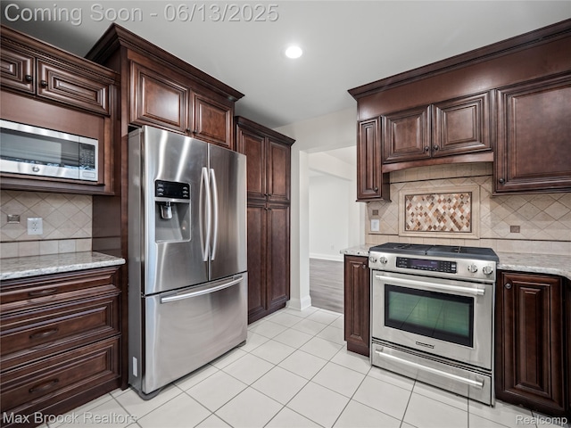 6150 Anne Dr, West Bloomfield, MI 48322 - kitchen with appliances with stainless steel finishes, backsplash, light tile patterned floors, dark brown cabinetry, and recessed lighting