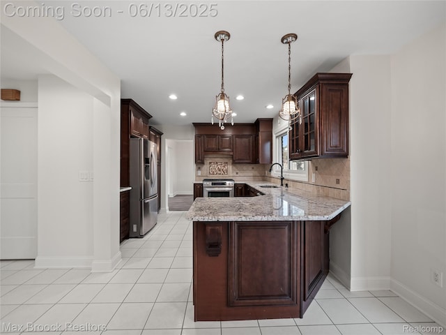 6150 Anne Dr, West Bloomfield, MI 48322 - kitchen featuring stainless steel appliances, a peninsula, a sink, baseboards, and dark brown cabinetry