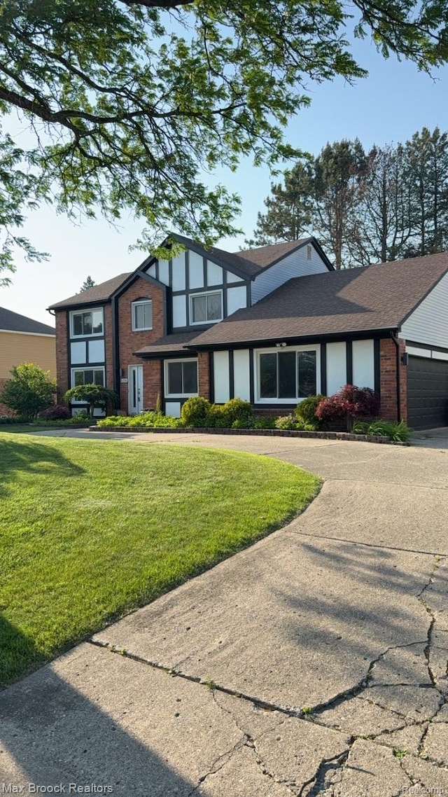 6150 Anne Dr, West Bloomfield, MI 48322 - tudor home featuring driveway, brick siding, a front yard, and an attached garage