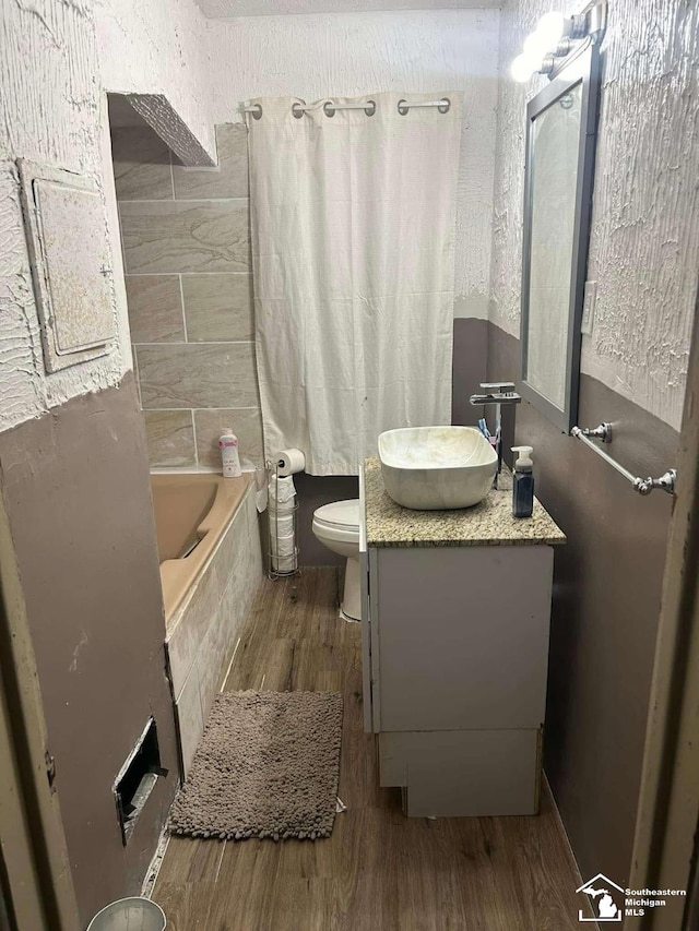 15016 Troester St, Detroit, MI 48205 - full bathroom featuring wood finished floors, vanity, toilet, and tiled shower / bath combo