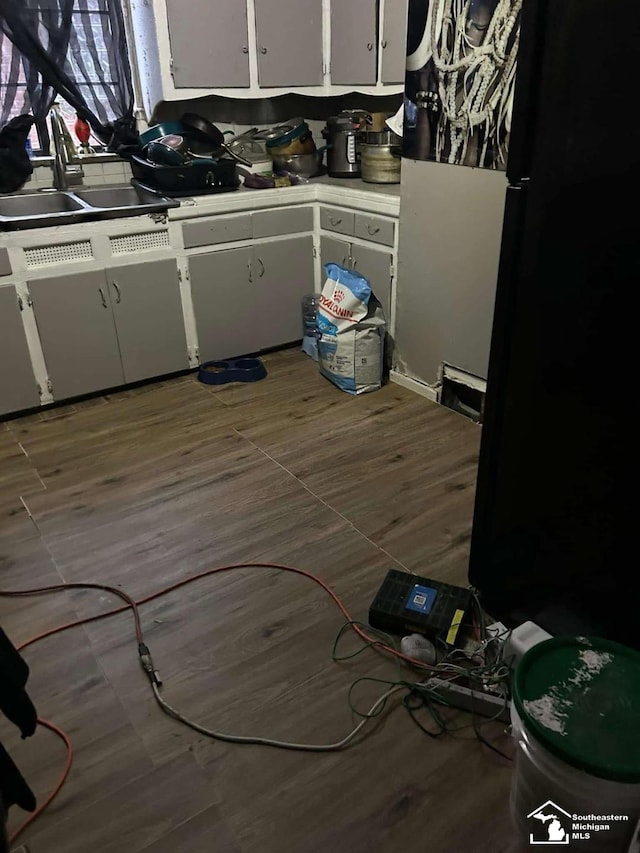 15016 Troester St, Detroit, MI 48205 - kitchen featuring white cabinetry, a sink, wood finished floors, and light countertops