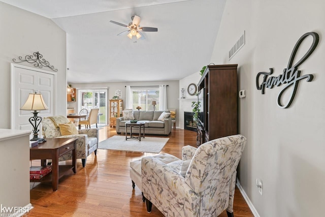 1273 Crystal Pointe Cir, Fenton, MI 48430 - living area featuring lofted ceiling, ceiling fan, light wood-type flooring, and a glass covered fireplace