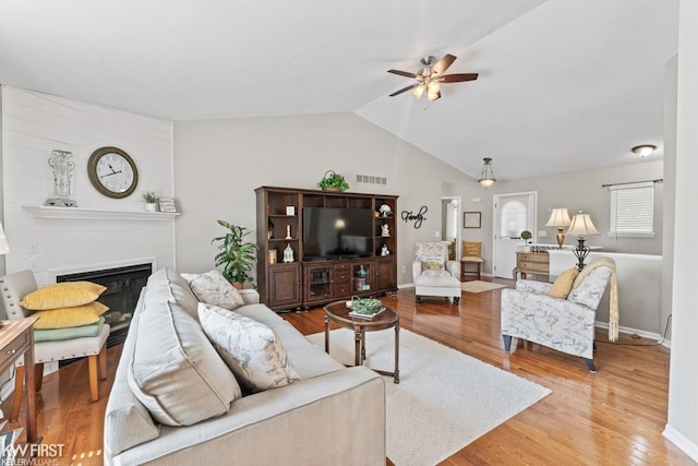 1273 Crystal Pointe Cir, Fenton, MI 48430 - living area with a ceiling fan, vaulted ceiling, wood finished floors, and a glass covered fireplace