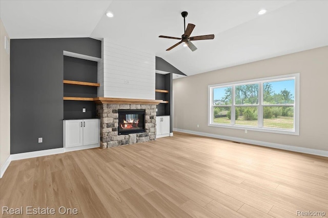 2763 Clivedon Rd, Howell, MI 48843 - unfurnished living room featuring vaulted ceiling, a ceiling fan, light wood-type flooring, baseboards, and a stone fireplace