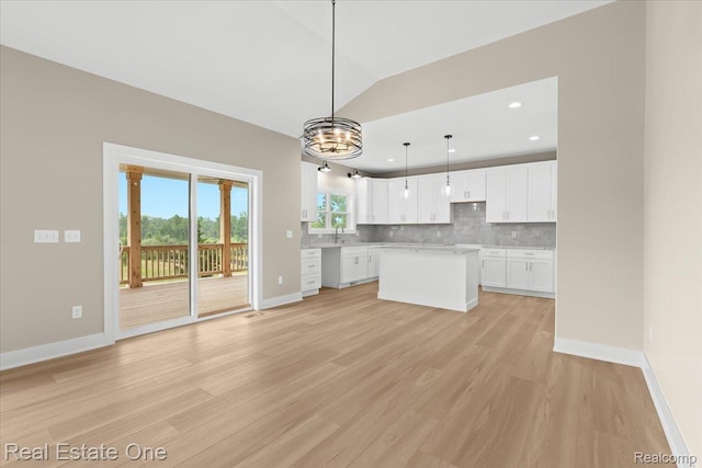 2763 Clivedon Rd, Howell, MI 48843 - kitchen featuring tasteful backsplash, baseboards, light wood finished floors, a center island, and white cabinetry