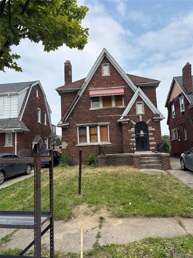 3260 Waverly St, Detroit, MI 48238 - tudor-style house with a chimney, brick siding, and a front yard