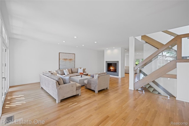 3856 Pine Lake Knoll Dr, West Bloomfield, MI 48324 - living area featuring light wood-type flooring, baseboards, a glass covered fireplace, recessed lighting, and stairway