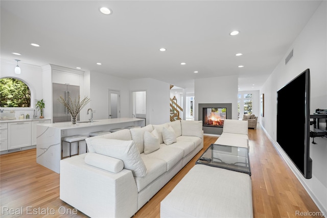3856 Pine Lake Knoll Dr, West Bloomfield, MI 48324 - living room with recessed lighting, light wood finished floors, and a multi sided fireplace