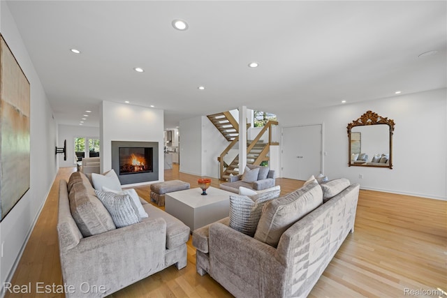 3856 Pine Lake Knoll Dr, West Bloomfield, MI 48324 - living room with stairs, recessed lighting, light wood-style floors, a glass covered fireplace, and baseboards