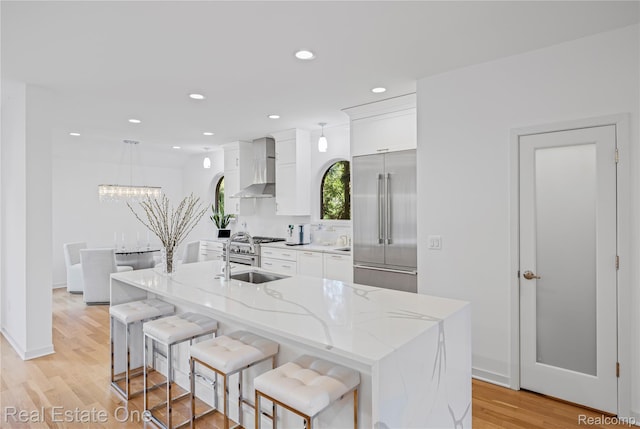 3856 Pine Lake Knoll Dr, West Bloomfield, MI 48324 - kitchen featuring built in fridge, wall chimney range hood, a sink, white cabinets, and recessed lighting